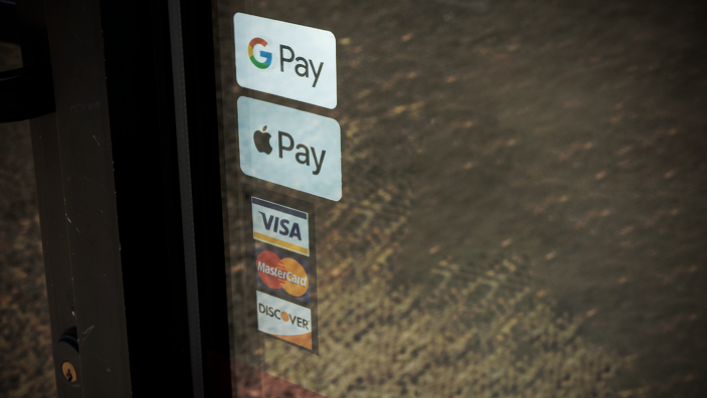 An entrance of a restaurant displaying accepted payment methods