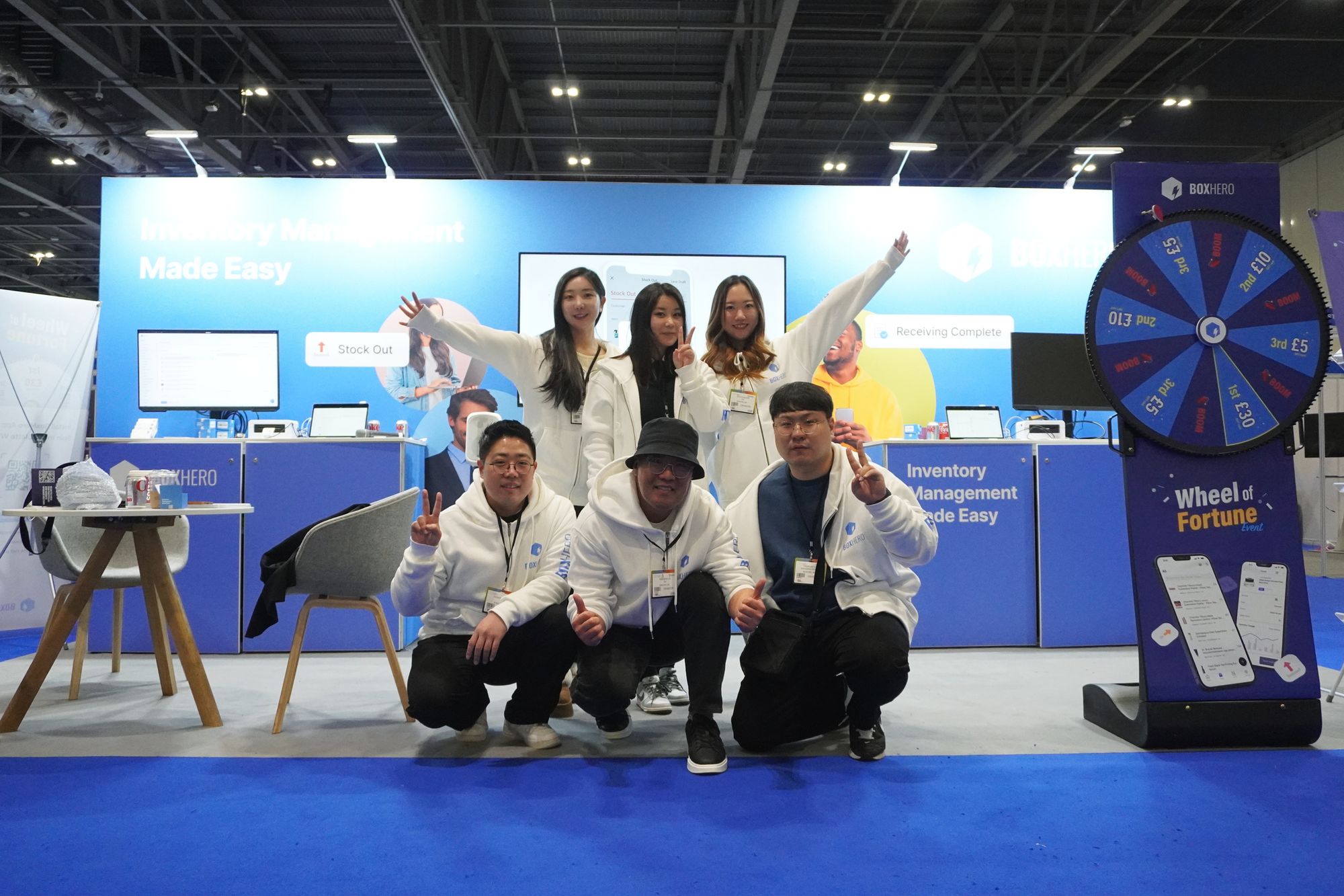 BoxHero team members taking a photo with the booth in the background