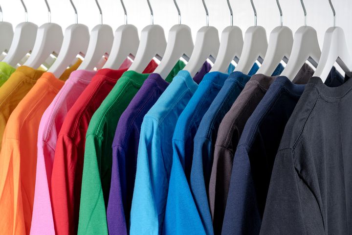 T-Shirts of different colors hanging on a rack.